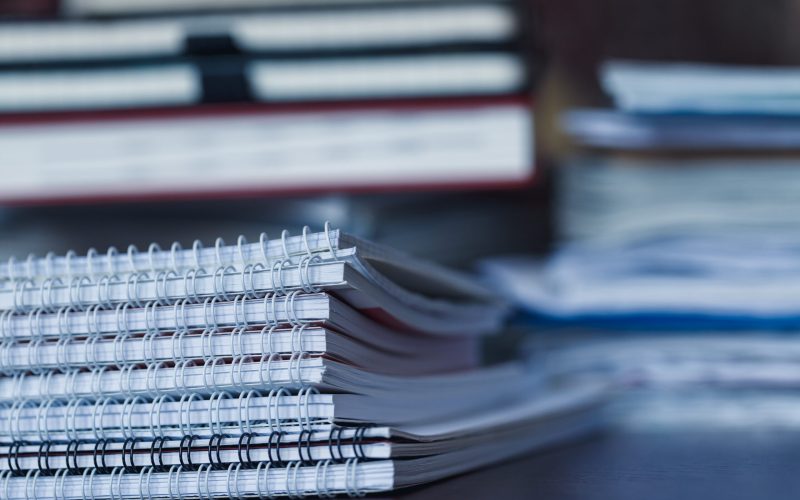 Accounting and taxes. Large pile of magazine, notebook and books closeup