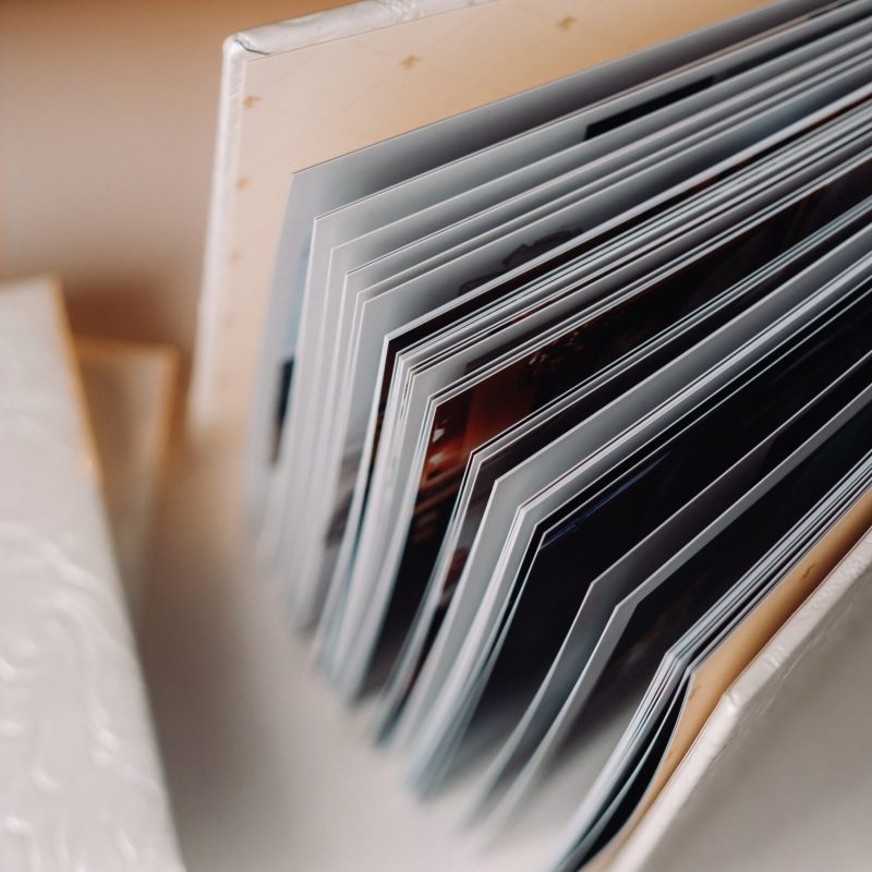 Composition of photo books in genuine white leather . Fragment of a photobook binding.